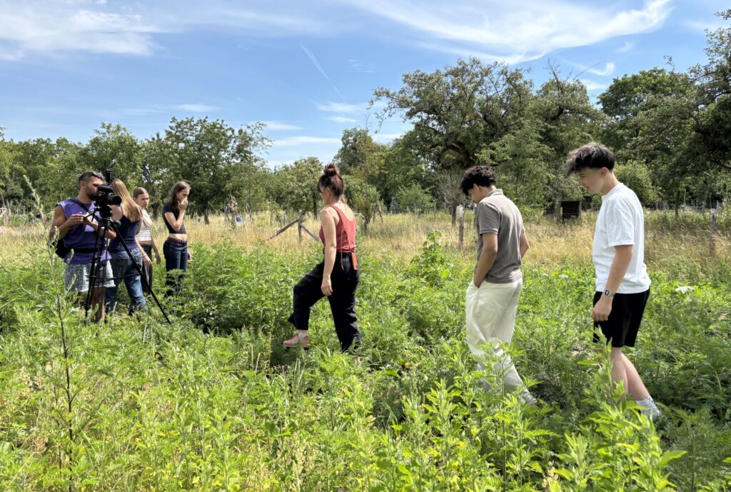 Gruppe Jugendlicher auf dem Feld mit Kameramann